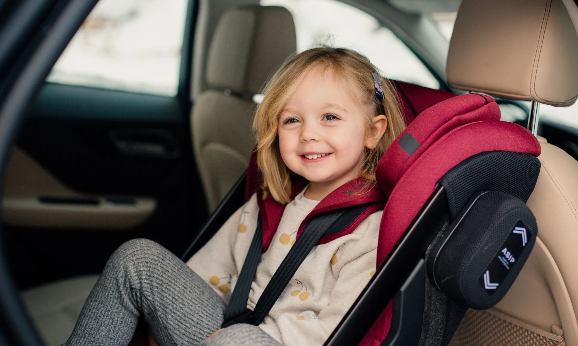Happy girl in car seat Axkid ONE 2.