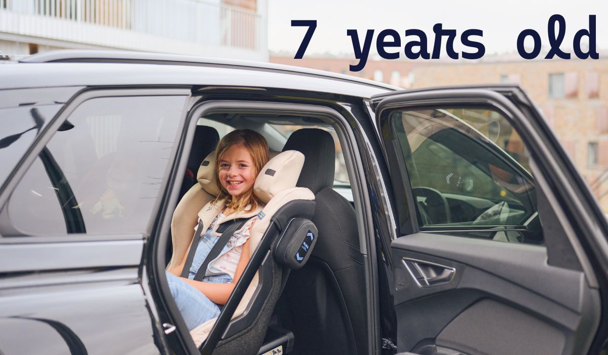 child sitting in rear facing car seat in the back seat with the car door open